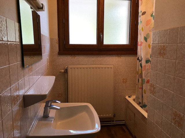Salle de bain avec lavabo, baignoire et une fenêtre.