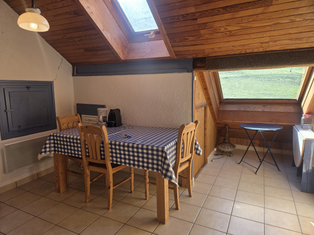 table à manger et chaises en bois, espace lumineux sous un velux