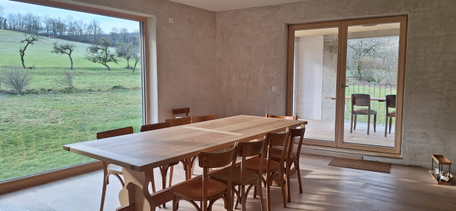 Belle table et chaises en bois face à la baie vitrée
