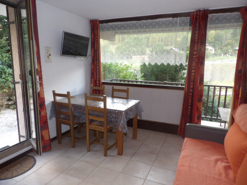 Coin séjour avec un canapé et une table pour 4 personnes, avec accès à la terrasse et au balcon