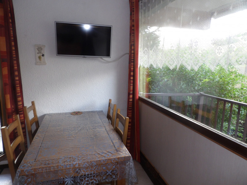 Table à manger pour 4 personnes à côté d'une grande baie lumineuse qui donne sur le balcon
