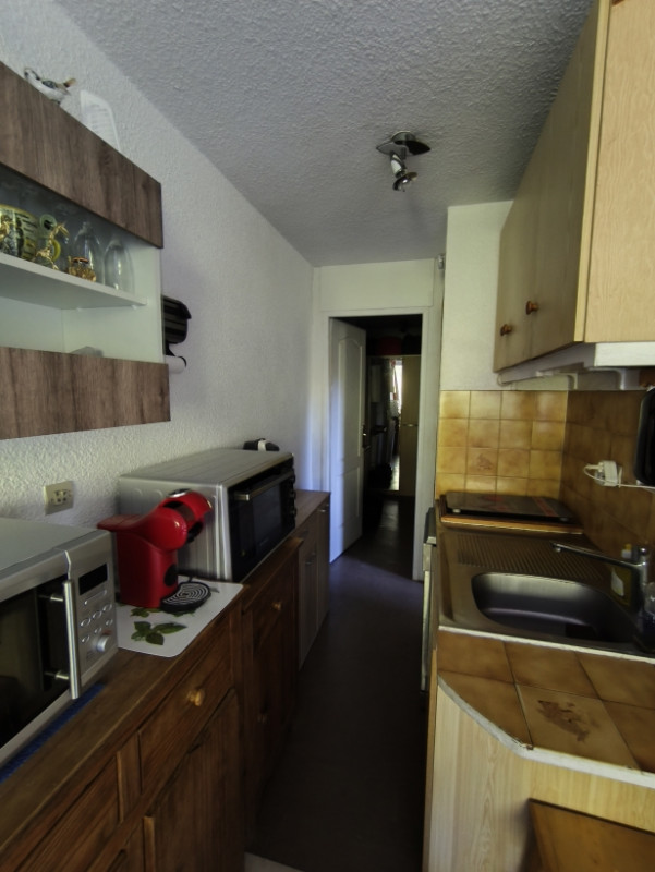 Vue générale de la cuisine équipée avec micro-onde et four combiné, plaques de cuisson